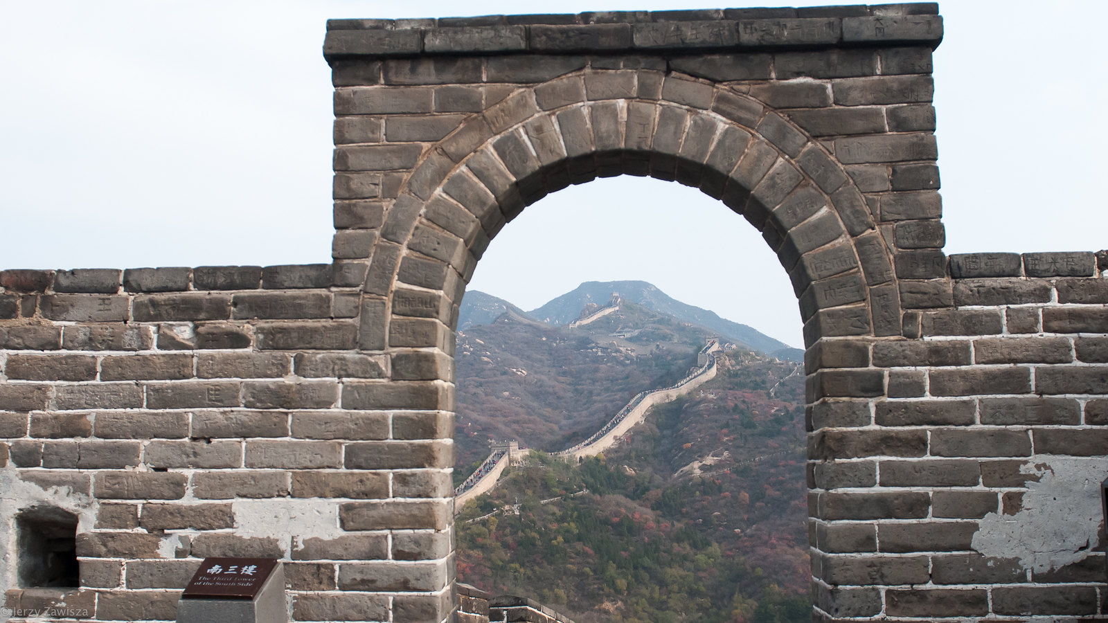 The Great Wall of China as seen through a stone arch.
