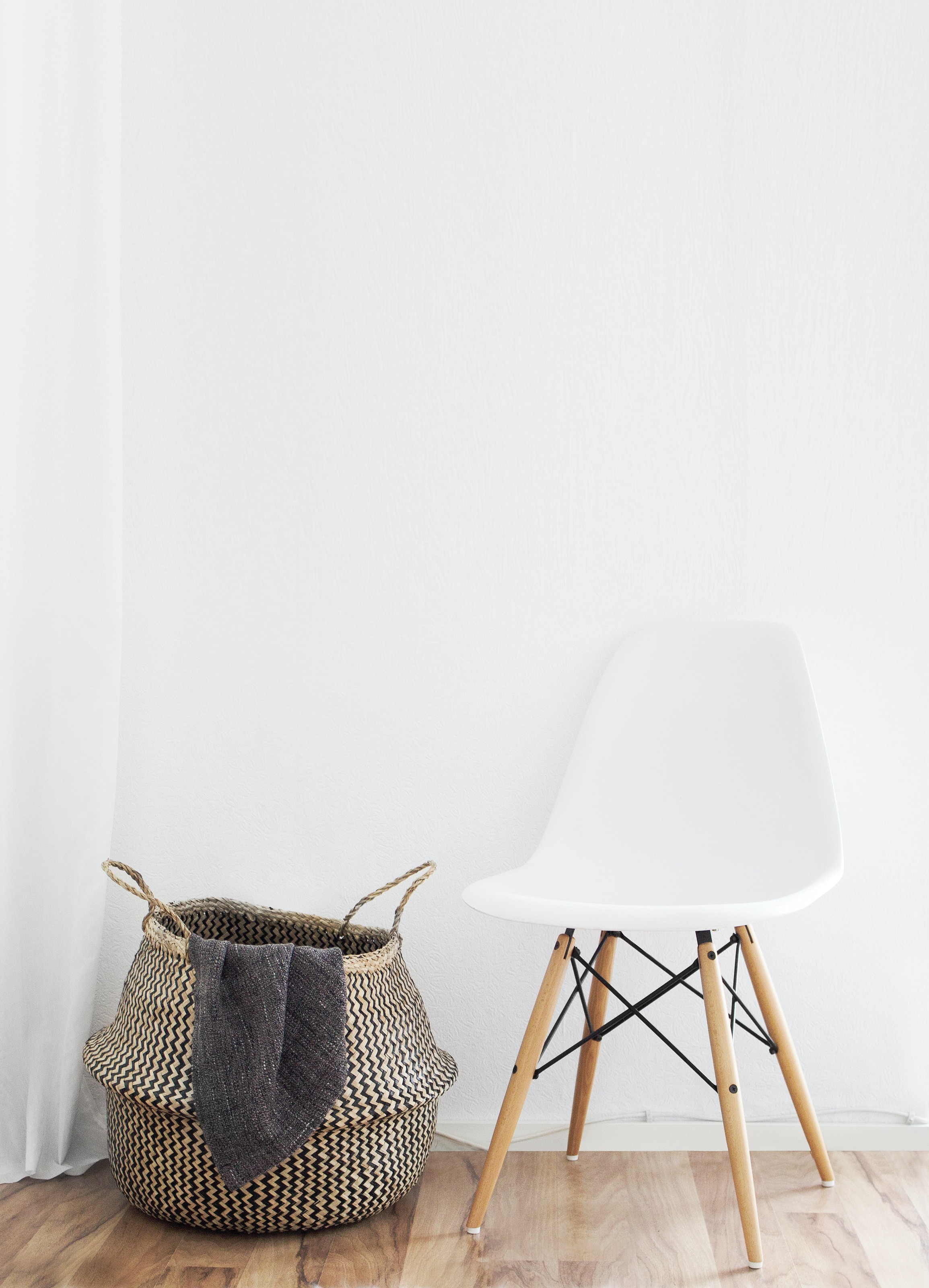 A woven basket next to a white chair