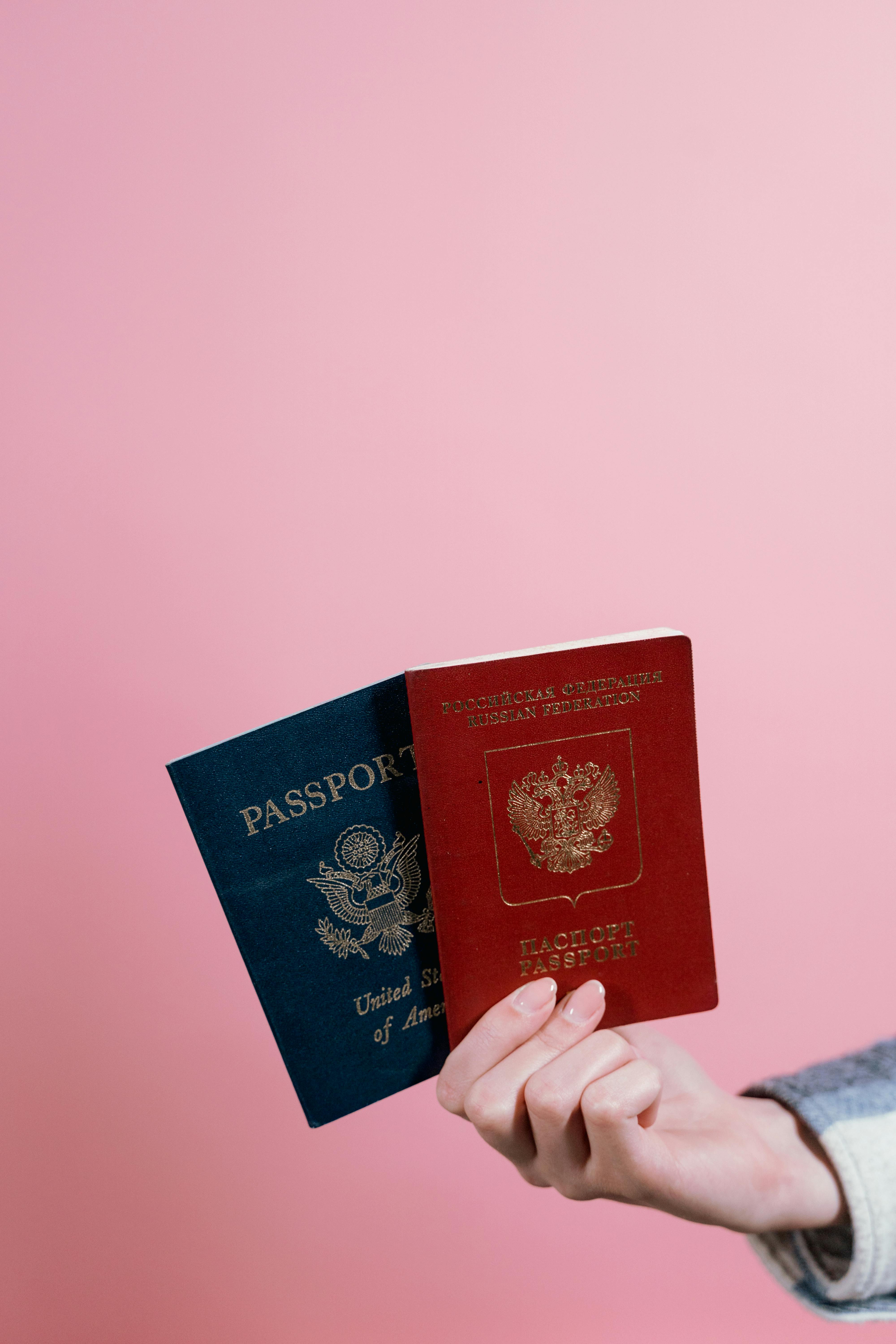 A hand holding two passports