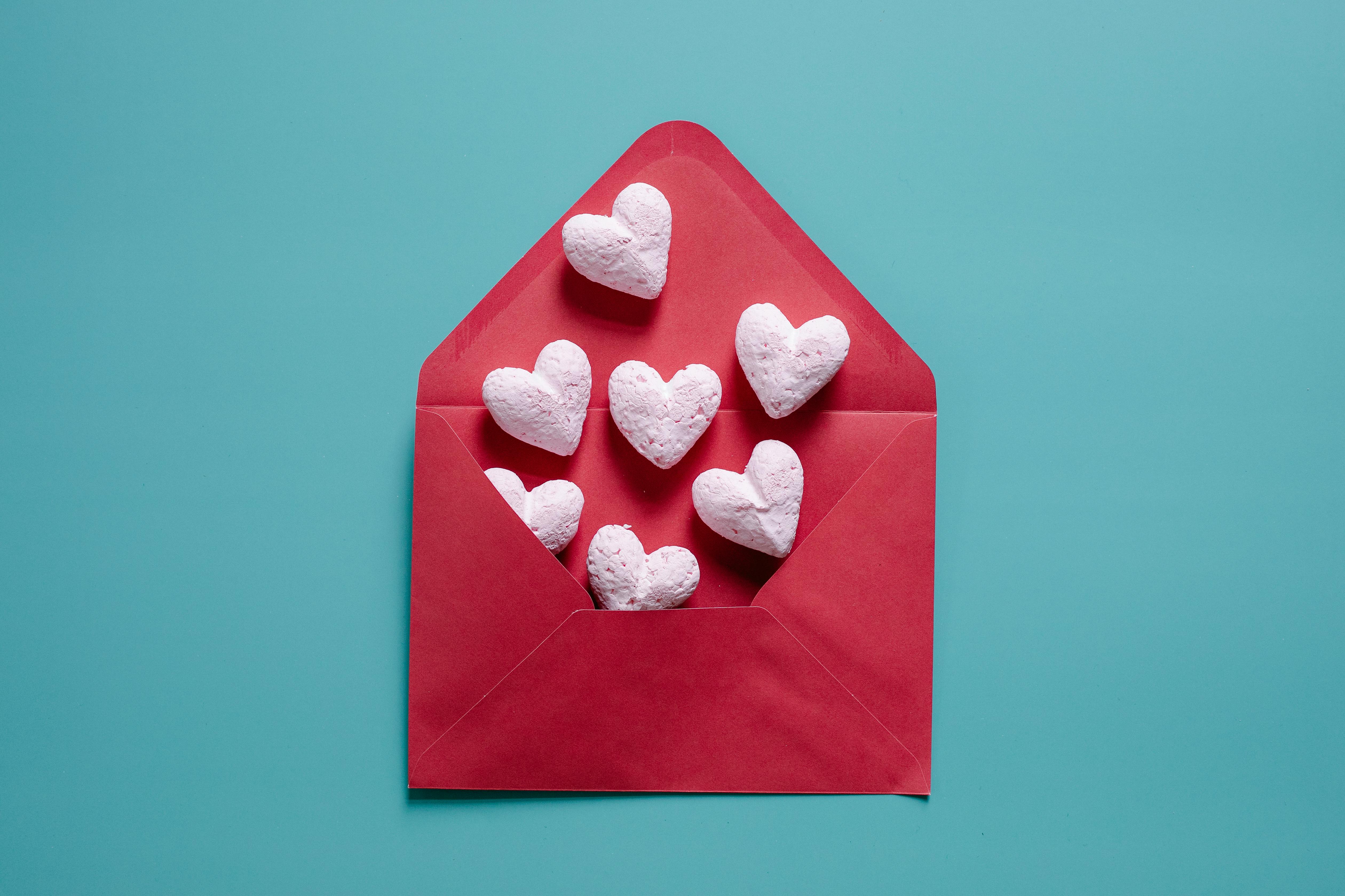 A red envelope with white hearts coming out of it